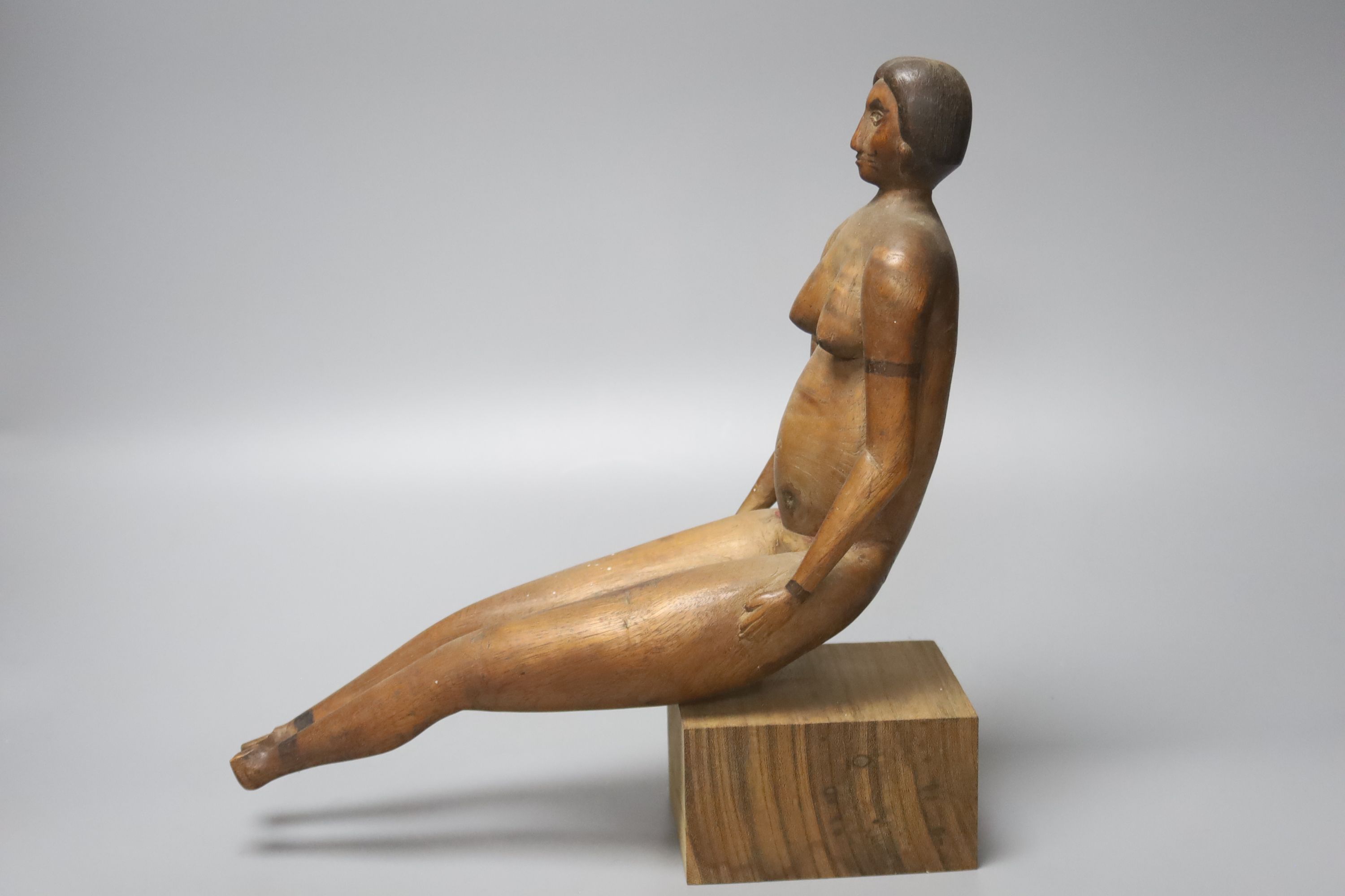 A South American carved wood figure of a seated nude lady, 20th century